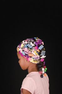 a young girl facing away from the camera with hair clips covering her hair