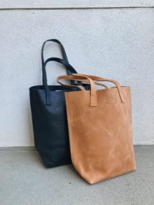 both leather tote bags, the brown in front of the black