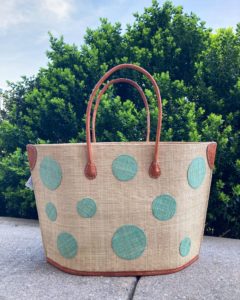 a big straw tote bag with mint green polka dots