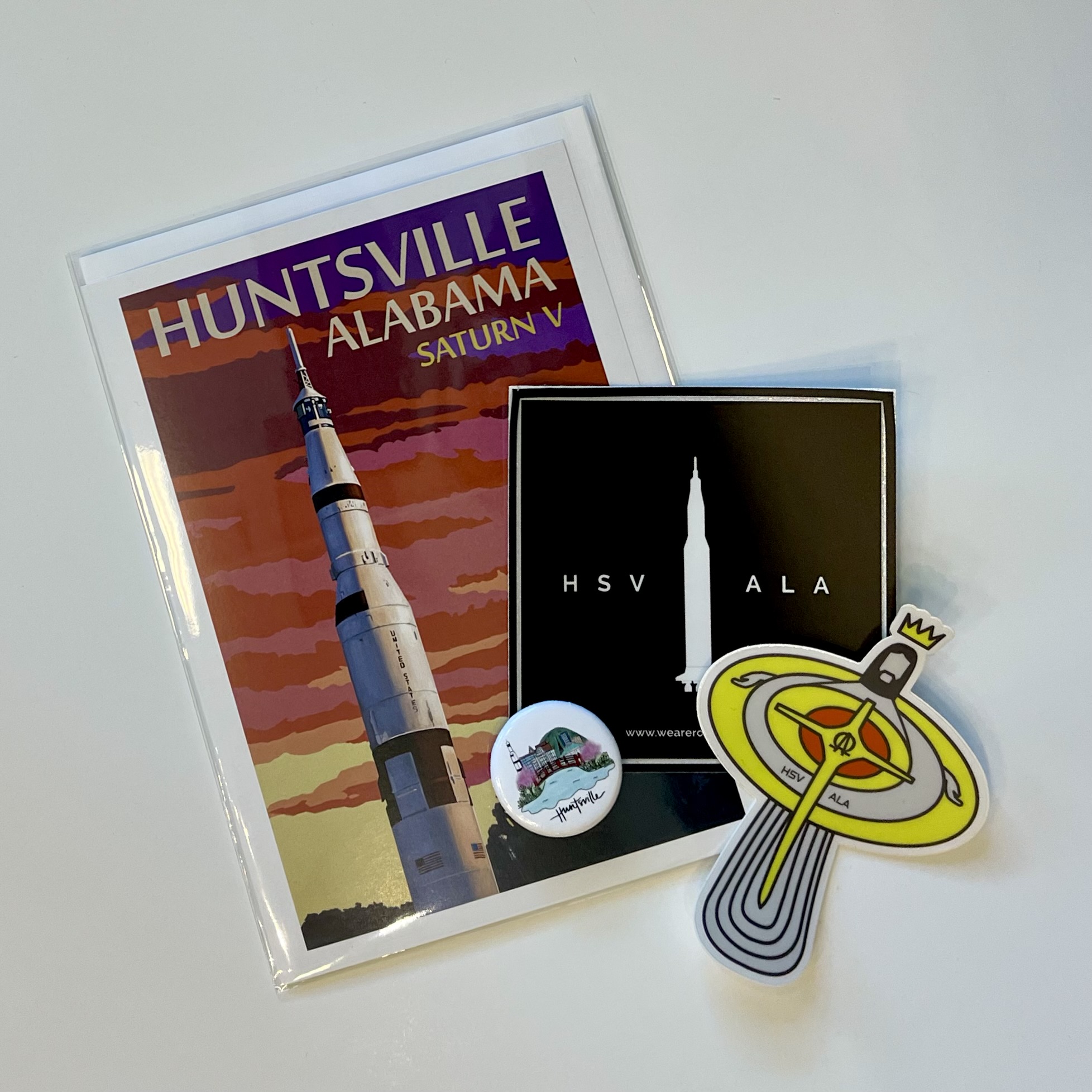 a huntsville postcard, two huntsville stickers and a huntsville pin